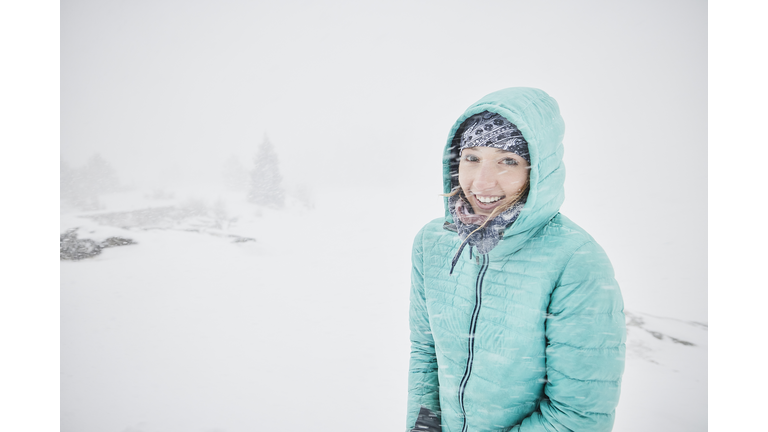 Portrait of smiling woman bundled up in snow storm