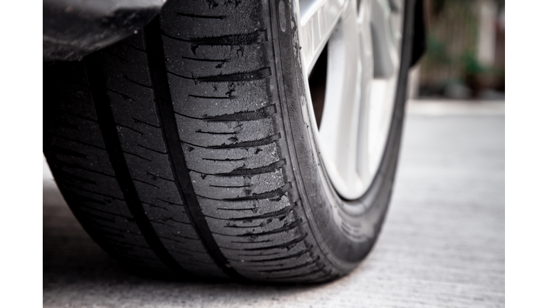 Tire wear concept. Danger of using old car bald tire with very little tread remaining.