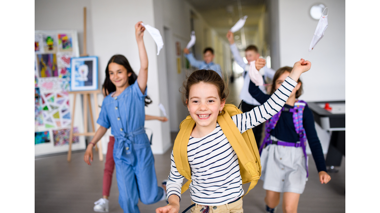 Group of cheerful children going home from school after covid-19 quarantine and lockdown.