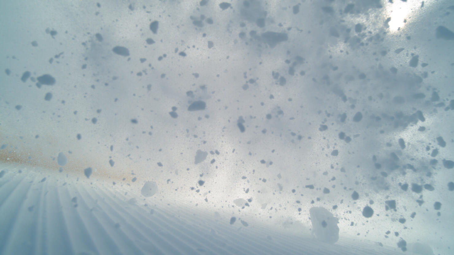 POV: Wild avalanche rushes down the groomed ski slopes in the beautiful Alps.