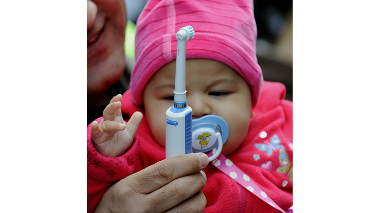 A baby tries to touch a battery operated