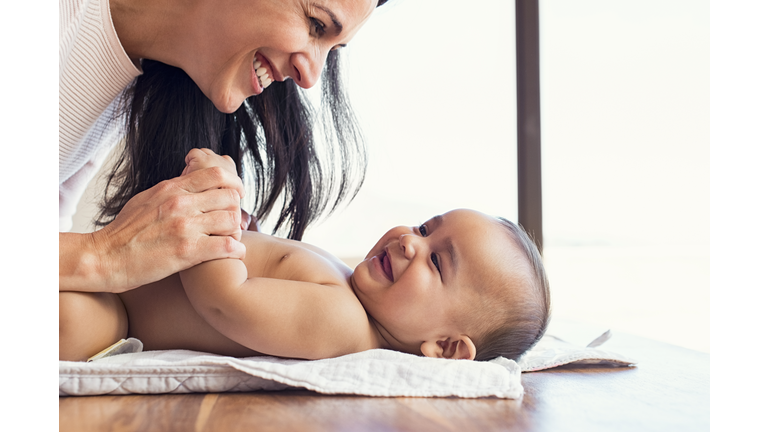 Mother changing diaper to toddler