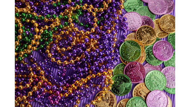 Green, gold, and purple Mardi Gras beads and coins background