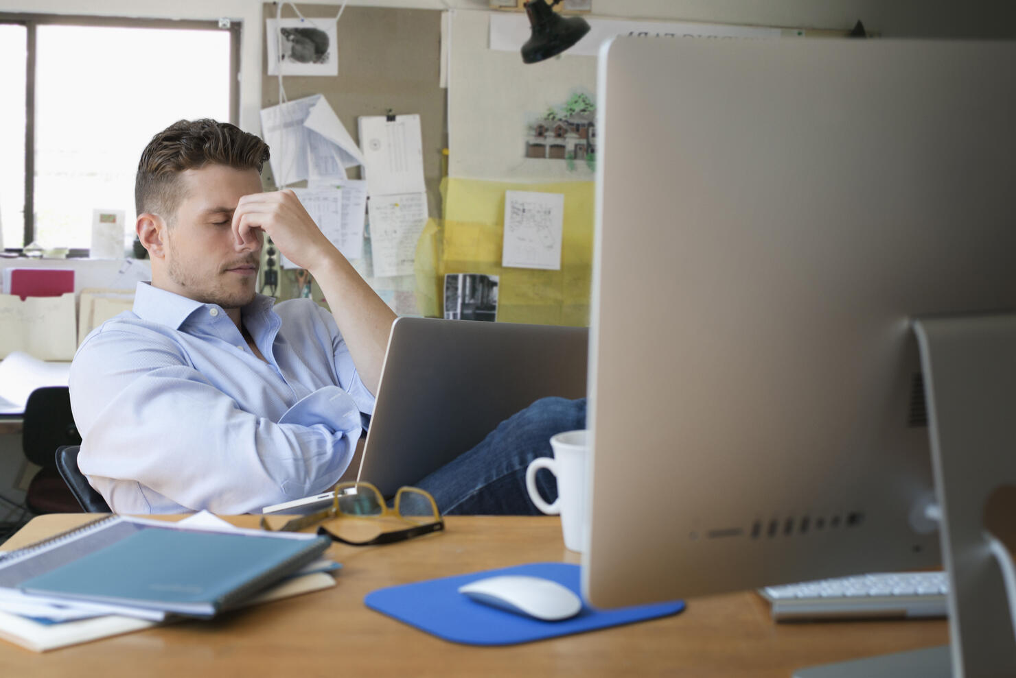 Frustrated Caucasian businessman with laptop in office