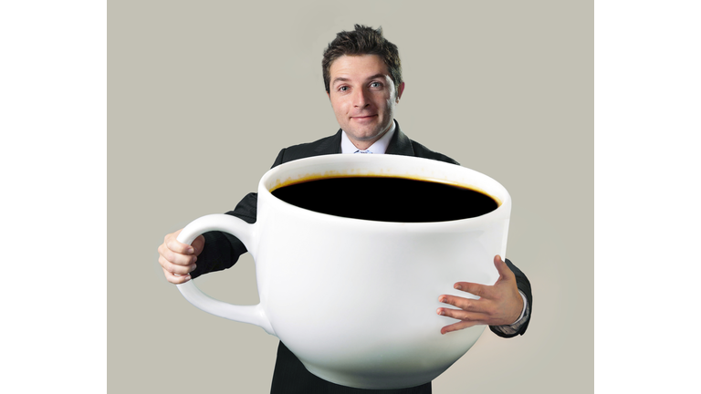 happy businessman holding funny huge  oversized cup of black cof