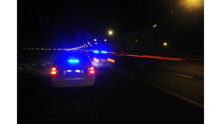 Police cars with blue flashing lights on a night patrol