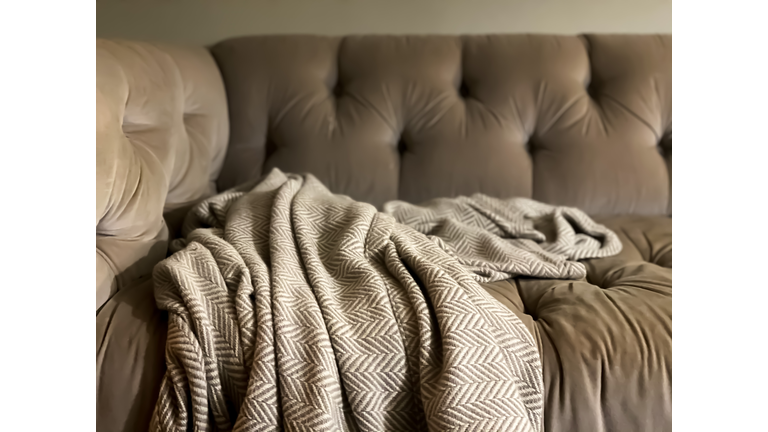 comfortable nook on tufted sofa with herringbone print cashmere throw blanket