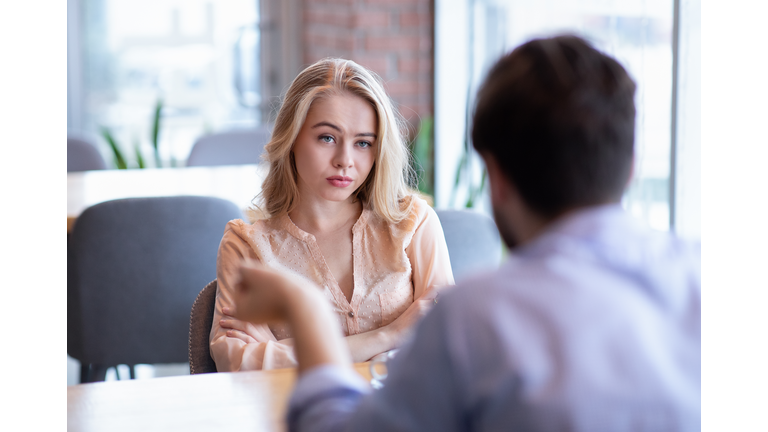 Bad date. Young woman feeling bored during dinner at cafe, unhappy with her boyfriend, disinterested in conversation