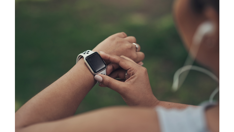 Shot of a woman using her smartwatch during a workout