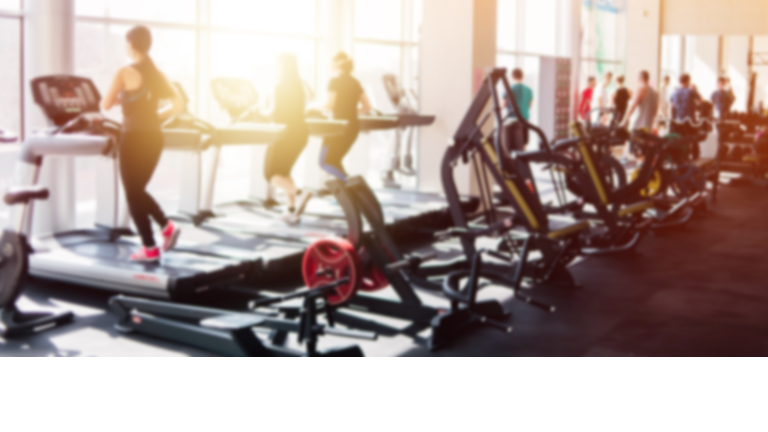 Blurred photo of a gym with people on treadmills