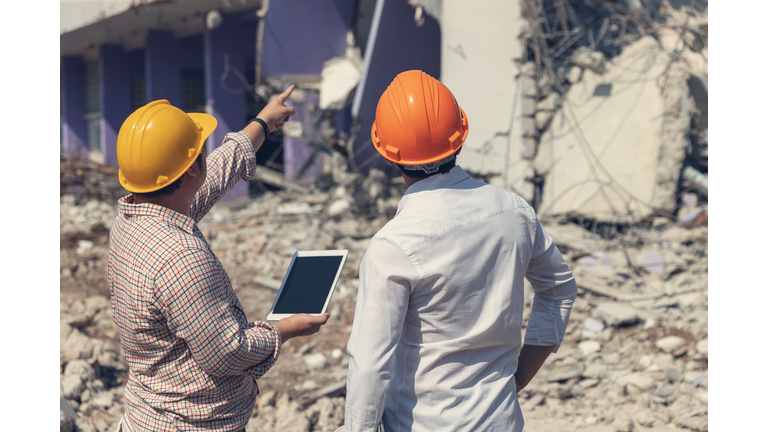 Engineer architect and worker operation control demolish old building.