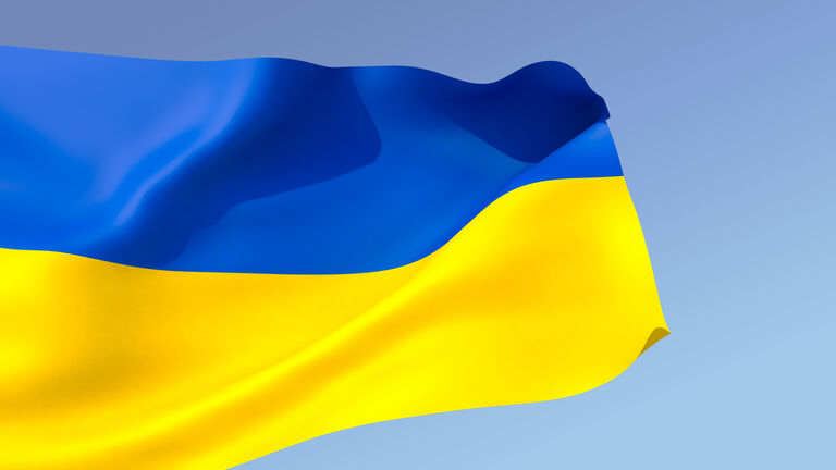 3D illustration. The large flag of Ukraine unfolds in the wind against blue sky background