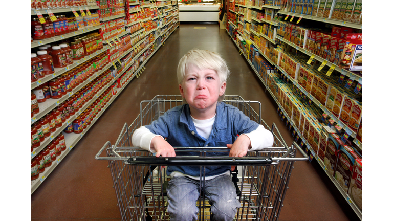 Boy crying in grocery cart.