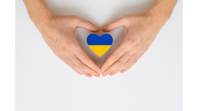 The national flag of Ukraine in female hands. The concept of patriotism, respect and solidarity with the citizens of Ukraine