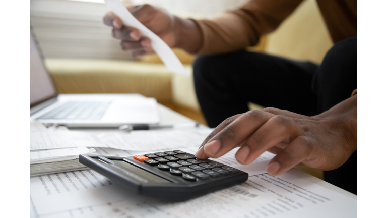 Close up of african american man with calculator checking bills