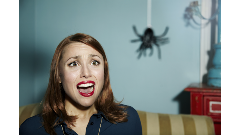 Shocked woman looking at spider.