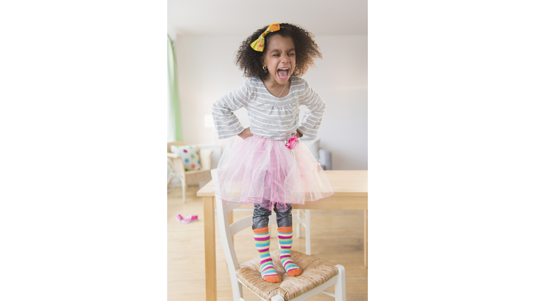 African American girl shouting on chair