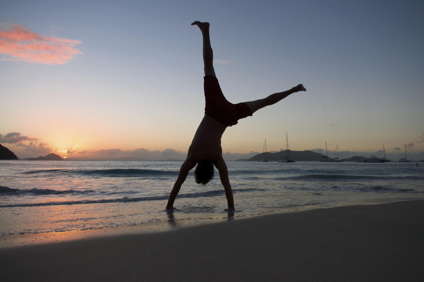 Silhouette of Man Doing Cartwheel on Sunset Beach