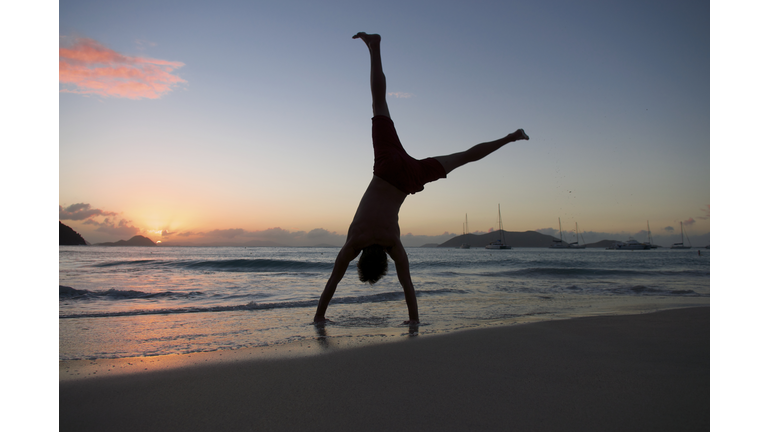 Silhouette of Man Doing Cartwheel on Sunset Beach