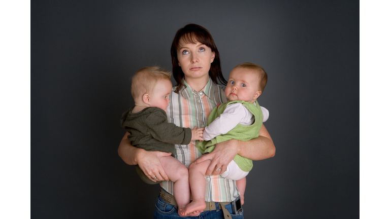 Mother holding twin babies (6-9 months)
