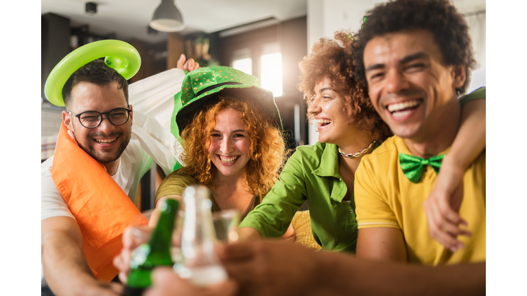Multiethnic Group Of Young People Having Fun And Drinking Beer Together. Ireland national symbols. St Patricks Day.