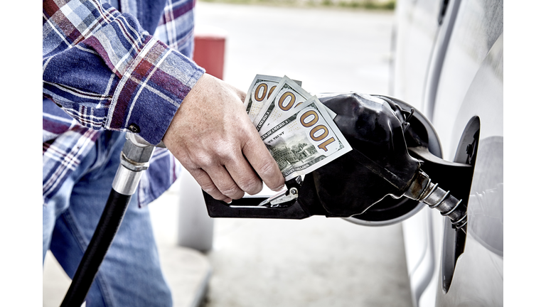 Mans Hand holding Cash while Refueling Vehicle
