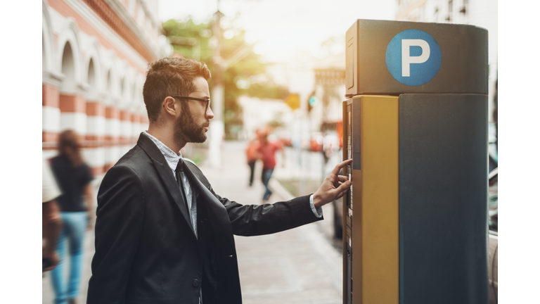 Businessman using Parking Meter outdoors