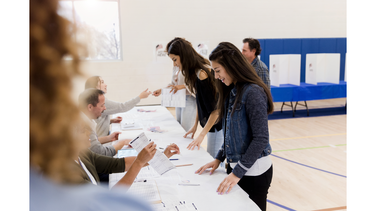 Women stand in row while signing up to vote