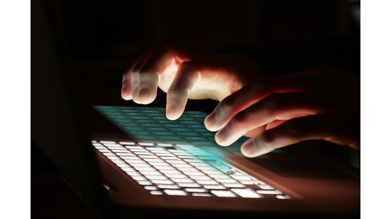 Close up of a hand typing on the technological, futuristic and holographic keyboard.