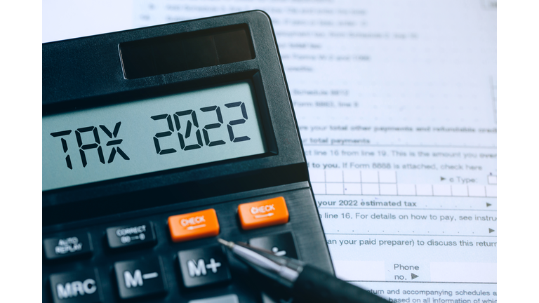 Word Tax 2022 on the calculator on documents.Income Statement. paying the tax rate. Taxation, taxes burden.Business and tax concept.