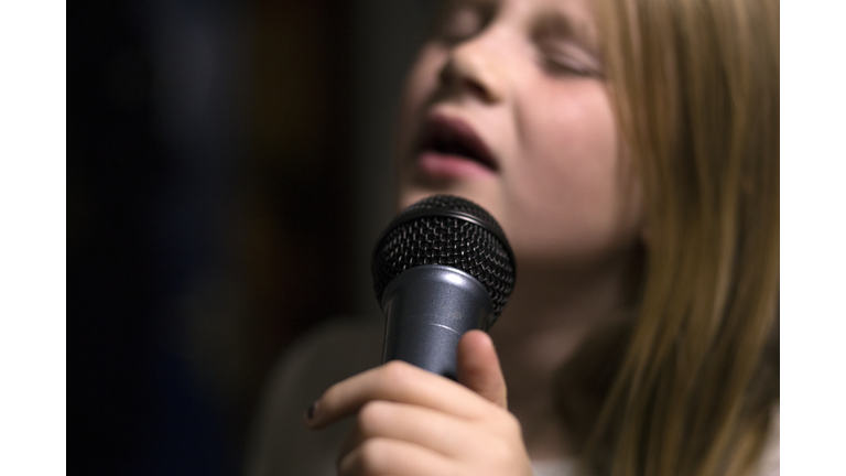 Girl holding microphone and singing