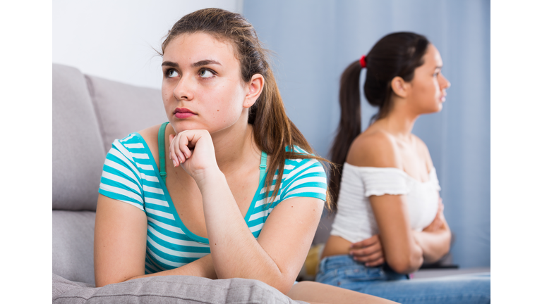 Quarreled girls apart on couch