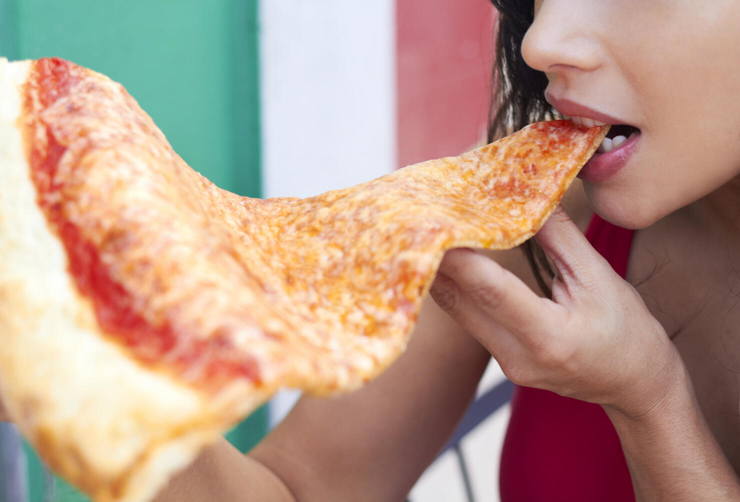 Woman Eating Large Slice Of Pizza