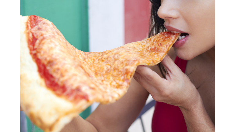 Woman Eating Large Slice Of Pizza