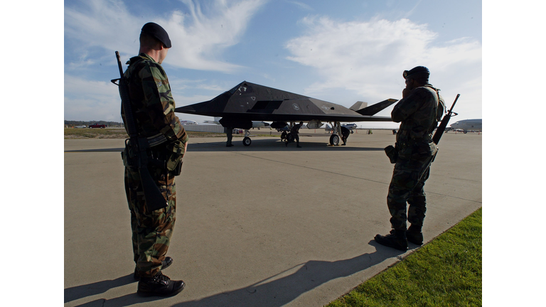Two United States Air Force airmen guard an F-117