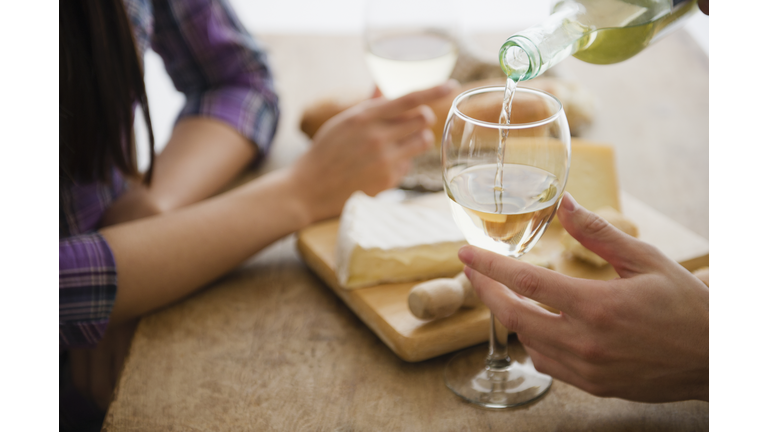 Close up of couple pouring wine and dining