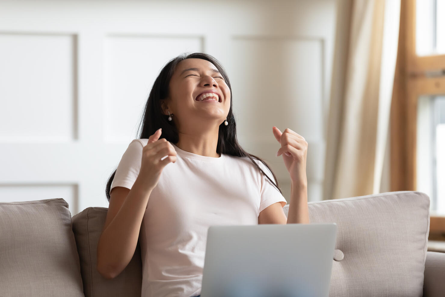 Asian woman received news by email on computer feels overjoyed