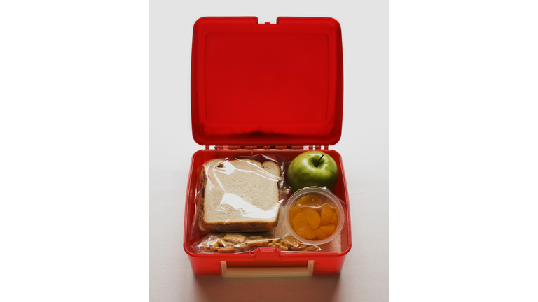 A lunch box with a sandwich and snacks