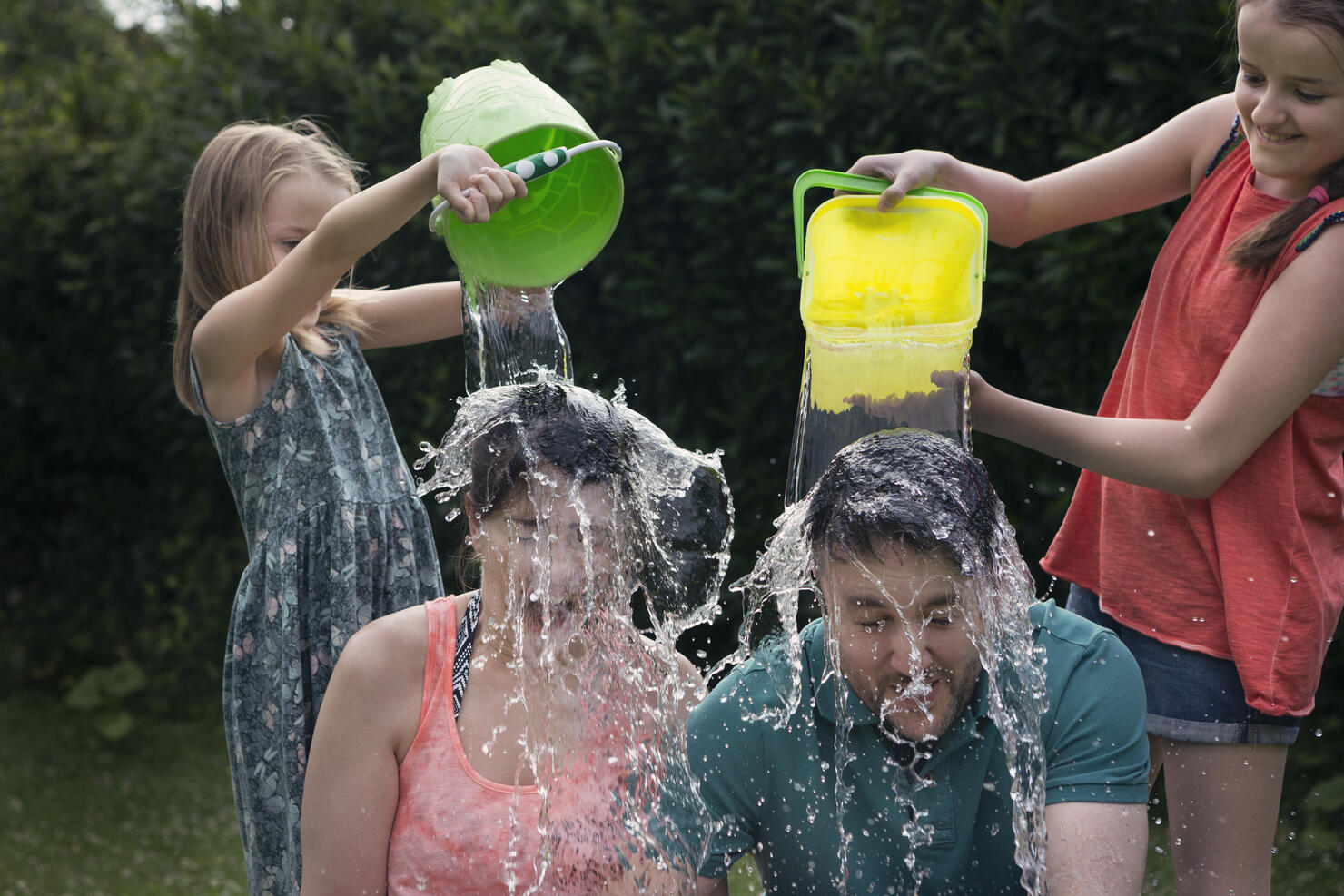 Children throwing buckets of water over adults
