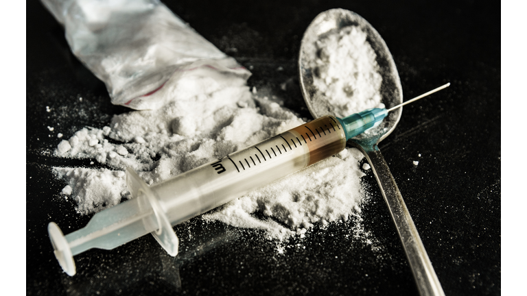 A drug syringe and a spoon with cooked heroin