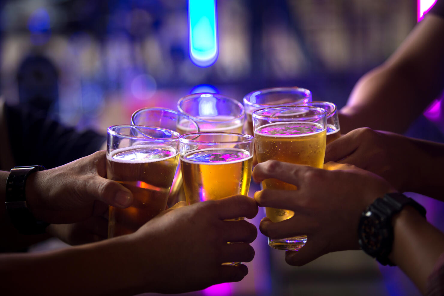 Group of  young people hands toasting and cheering aperitif beers half pint