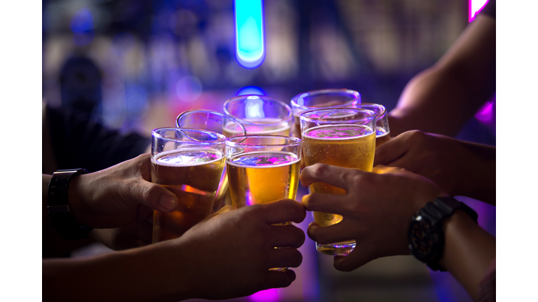 Group of  young people hands toasting and cheering aperitif beers half pint