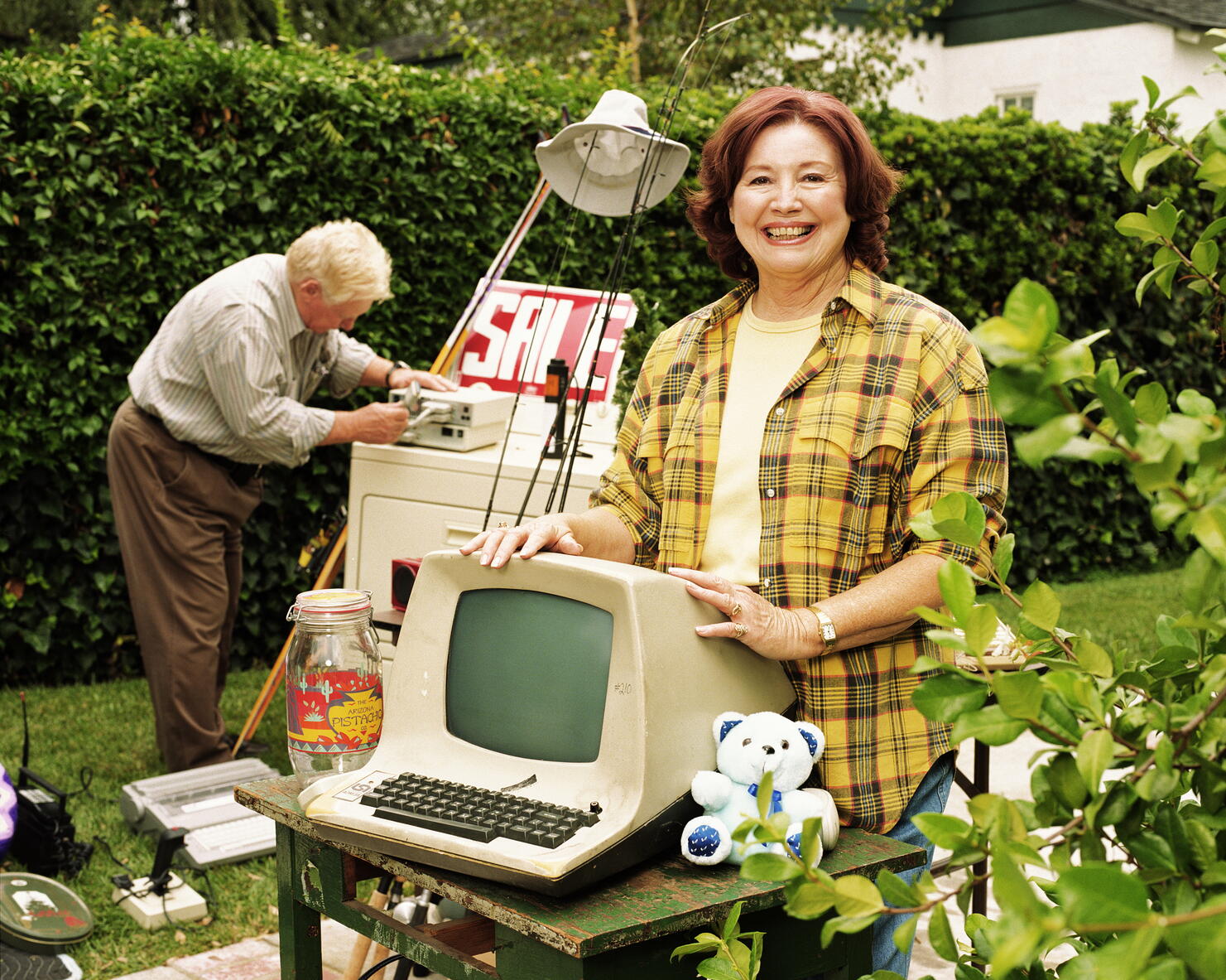 Mature woman standing by old computer monitor at yard sale