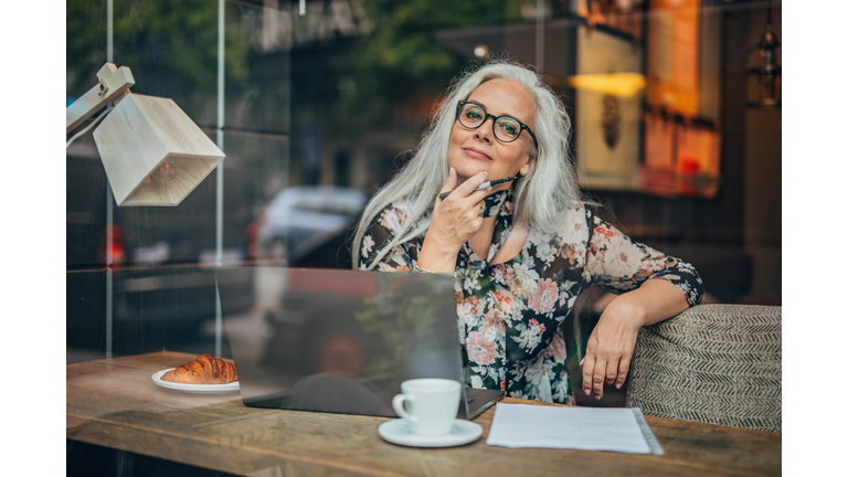 Old business woman sitting in cafe alone