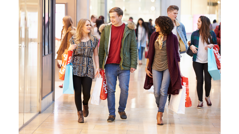 Group Of Young Friends Shopping In Mall Together