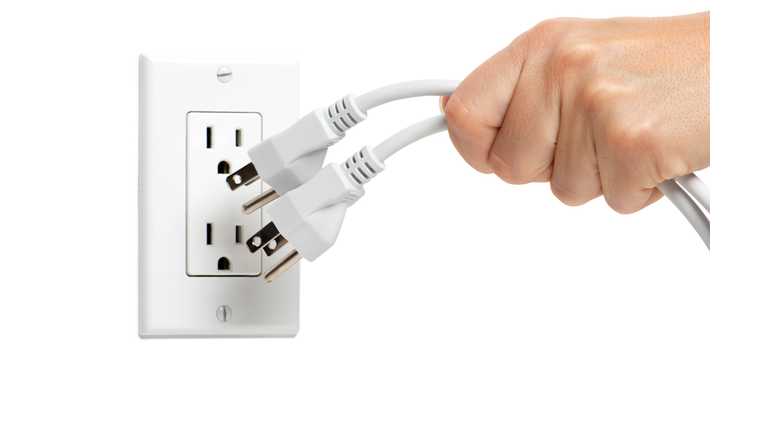woman unplugging electrical cords on white