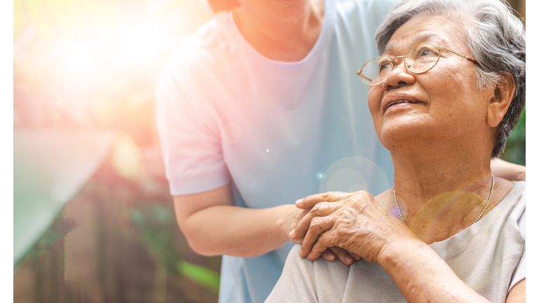 Caregiver, carer hand holding elder hand in hospice care. Philanthropy kindness to disabled concept.