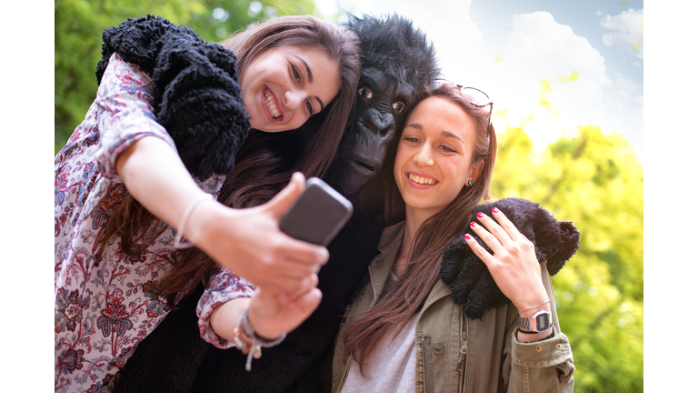 Happy friends and a Gorilla Taking Photo with Mobile Phone