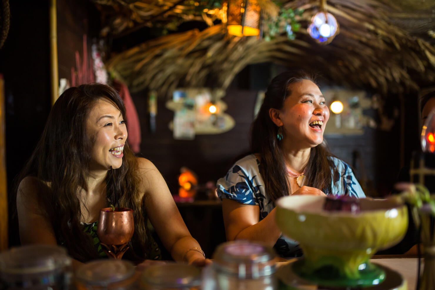 People drinking and enjoying themselves in a tropical themed restaurant or bar
