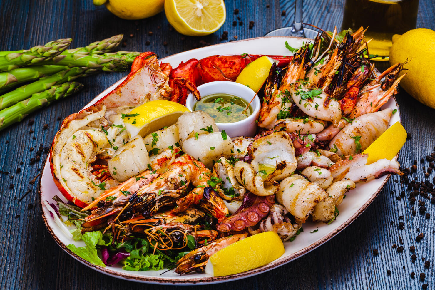 Seafood platter. Grilled lobster, shrimps, scallops, langoustines, octopus, squid on white plate.